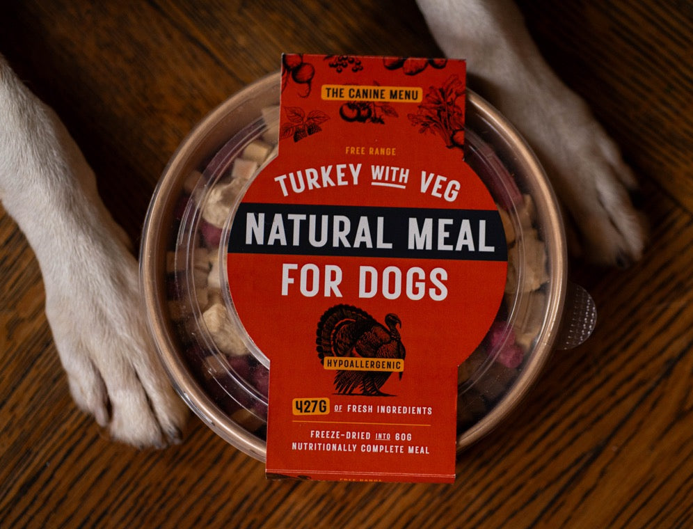 Dog food container with a red label on a wooden floor