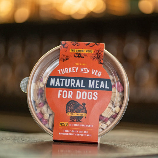 Pet food packaging with 'Natural Meal for Dogs' label on a blurred background